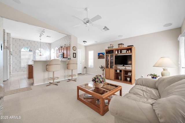 carpeted living room with ceiling fan and a healthy amount of sunlight