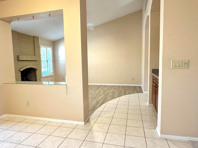 kitchen with a brick fireplace and light hardwood / wood-style flooring