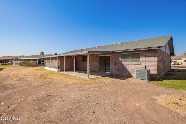 rear view of property with a sunroom, central AC unit, and a patio