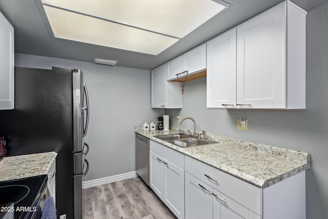 kitchen with sink, light hardwood / wood-style floors, white cabinets, and appliances with stainless steel finishes