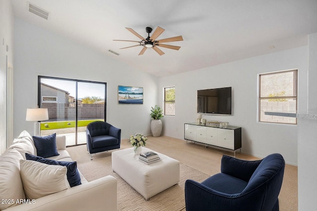 living room featuring a wealth of natural light, lofted ceiling, and light colored carpet