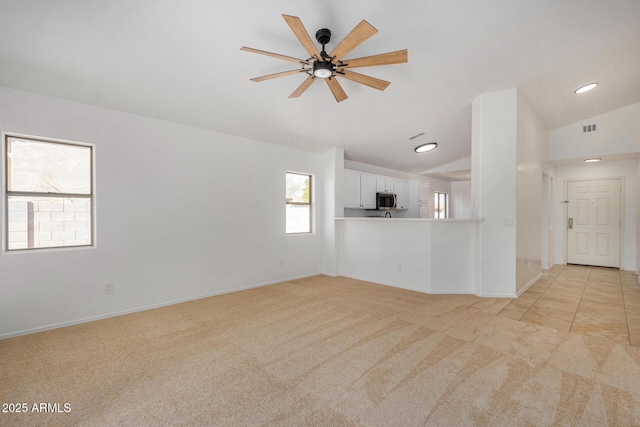 unfurnished living room with lofted ceiling, light carpet, and ceiling fan