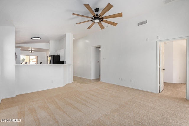 unfurnished living room with ceiling fan, light colored carpet, and vaulted ceiling