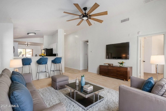 living room with lofted ceiling, light carpet, and ceiling fan