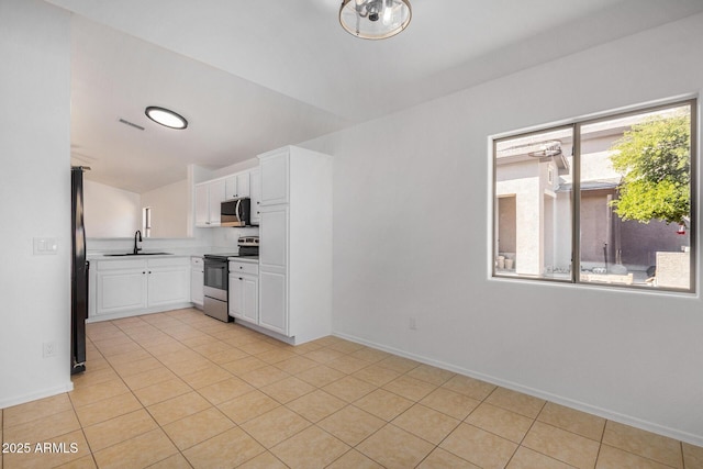 kitchen with white cabinetry, sink, light tile patterned floors, and appliances with stainless steel finishes