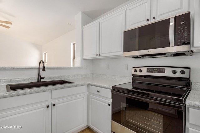 kitchen featuring white cabinetry, sink, vaulted ceiling, and stainless steel appliances