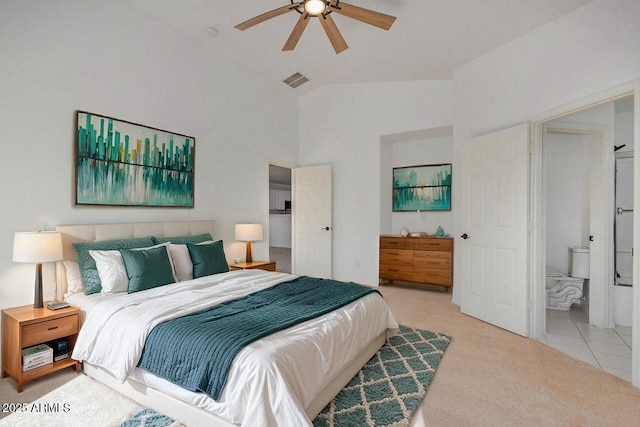 bedroom featuring connected bathroom, vaulted ceiling, light colored carpet, and ceiling fan