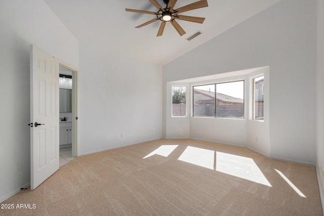 carpeted empty room featuring vaulted ceiling and ceiling fan