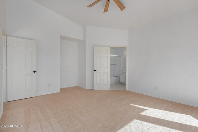 unfurnished bedroom with light colored carpet, ensuite bathroom, and high vaulted ceiling