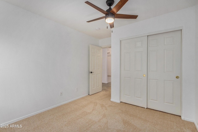 unfurnished bedroom with light colored carpet, a closet, and ceiling fan