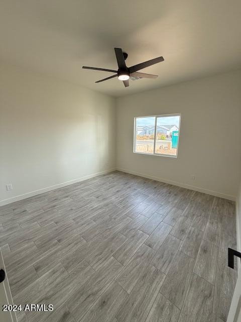 spare room featuring light wood-type flooring and ceiling fan