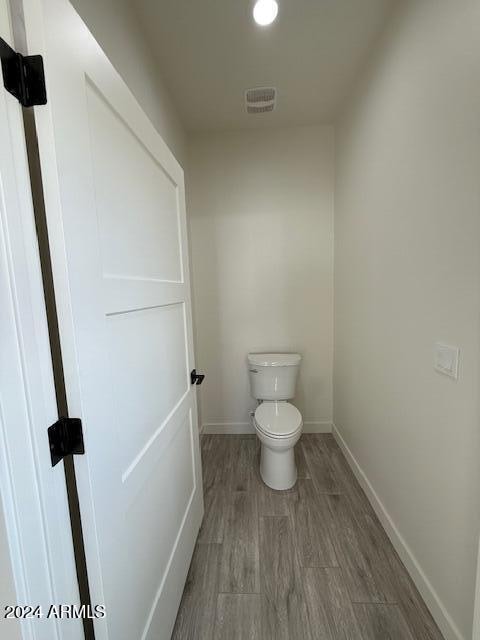 bathroom featuring hardwood / wood-style floors and toilet