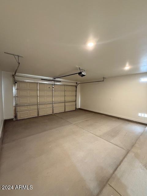 garage featuring a garage door opener and baseboards