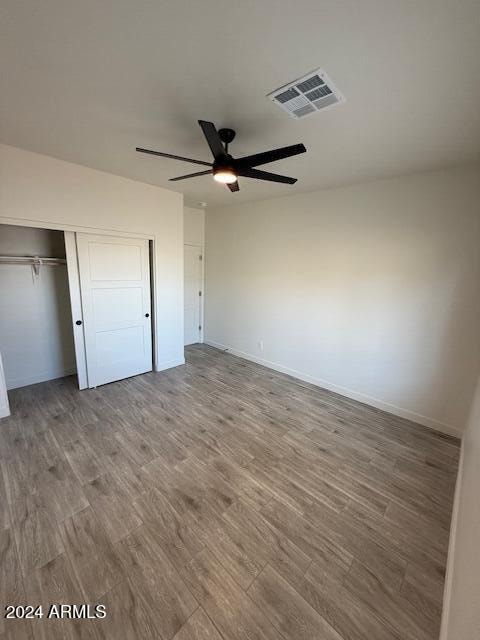 unfurnished bedroom featuring a closet, visible vents, and wood finished floors