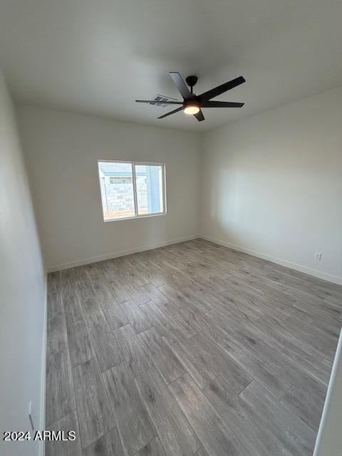 empty room with ceiling fan and light hardwood / wood-style floors