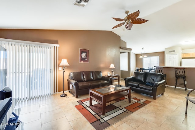 tiled living room with ceiling fan and lofted ceiling