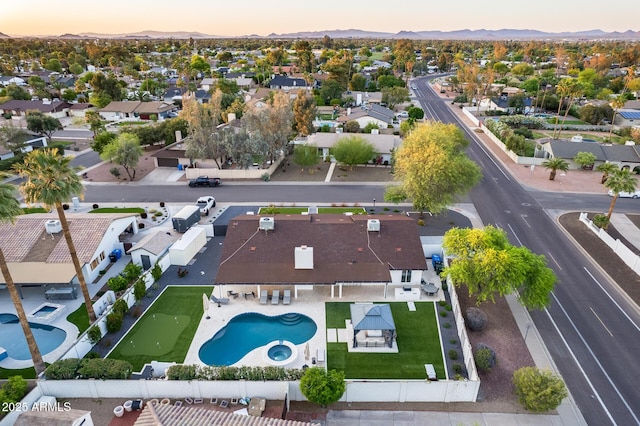 aerial view at dusk featuring a mountain view and a residential view
