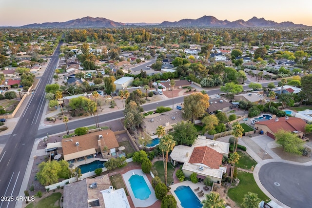 aerial view at dusk featuring a residential view and a mountain view