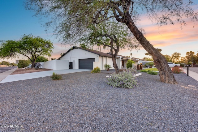 view of front of property with fence, an attached garage, and driveway