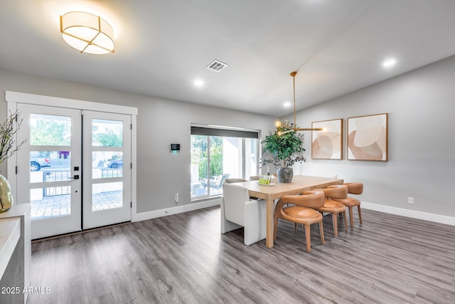 dining area featuring visible vents, baseboards, and wood finished floors