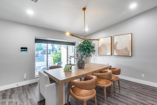 dining area featuring baseboards, lofted ceiling, and wood finished floors