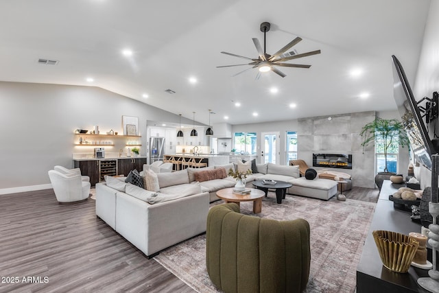 living area with recessed lighting, a ceiling fan, lofted ceiling, and wood finished floors