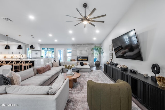 living room with visible vents, recessed lighting, ceiling fan, and a fireplace