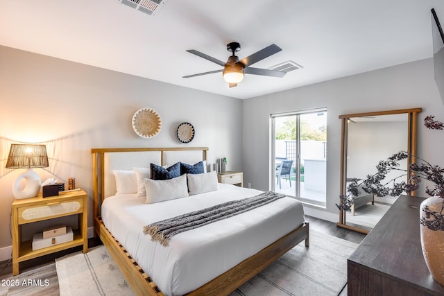 bedroom with access to outside, visible vents, and wood finished floors