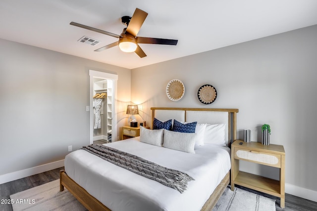 bedroom featuring visible vents, a ceiling fan, baseboards, and wood finished floors