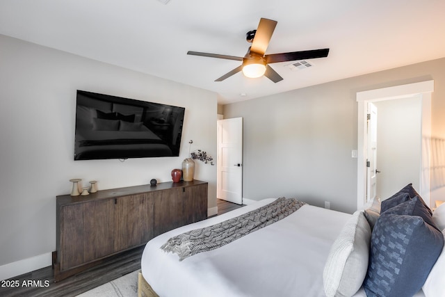 bedroom featuring visible vents, baseboards, ceiling fan, and wood finished floors