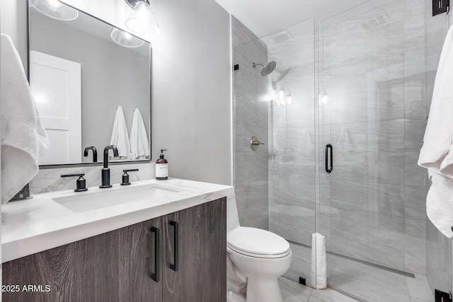 bathroom featuring vanity, toilet, and a stall shower