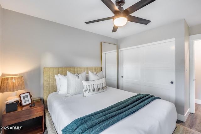 bedroom featuring a closet, baseboards, a ceiling fan, and wood finished floors