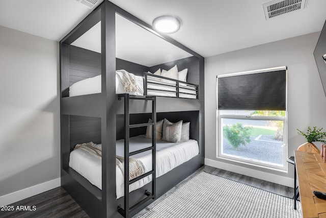 bedroom featuring baseboards, visible vents, and wood finished floors