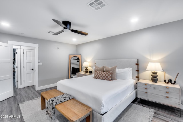bedroom featuring a ceiling fan, baseboards, visible vents, and wood finished floors