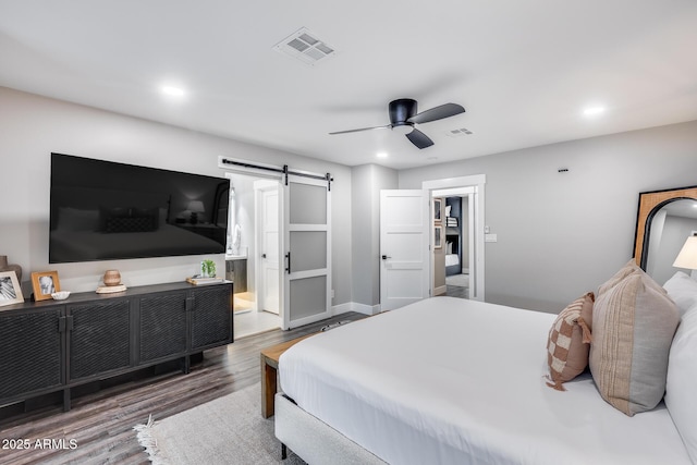 bedroom featuring a barn door, a ceiling fan, recessed lighting, wood finished floors, and visible vents