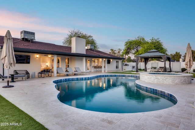 view of pool with central AC, a patio, a fenced backyard, a gazebo, and a pool with connected hot tub