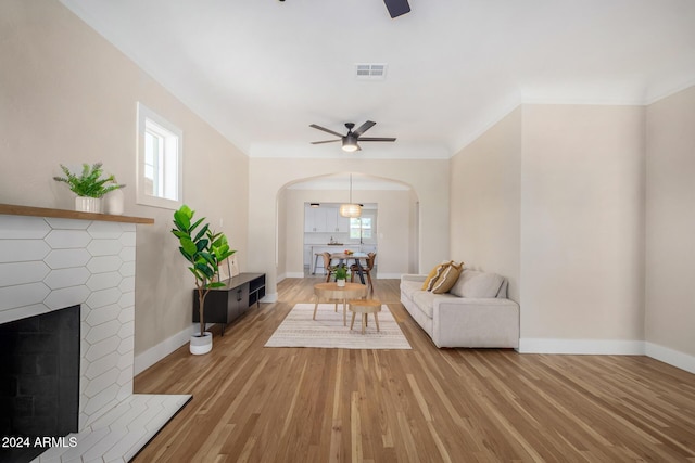 1921 E Yale St, Phoenix, AZ 85006 - living area featuring a ceiling fan, arched walkways, light wood-type flooring, and a brick fireplace