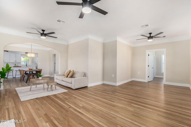 1921 E Yale St, Phoenix, AZ 85006 - living area with arched walkways, a ceiling fan, light wood-style flooring, and ornamental molding