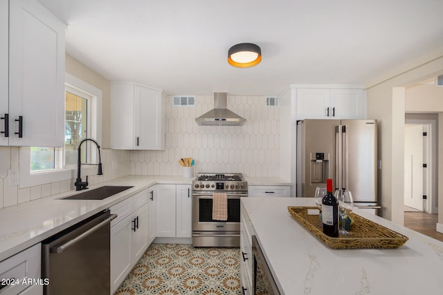 kitchen featuring white cabinets, high quality appliances, sink, and wall chimney exhaust hood