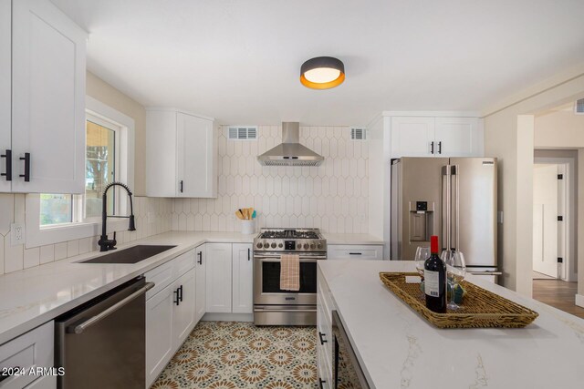 1921 E Yale St, Phoenix, AZ 85006 - kitchen featuring appliances with stainless steel finishes, wall chimney exhaust hood, backsplash, and white cabinets