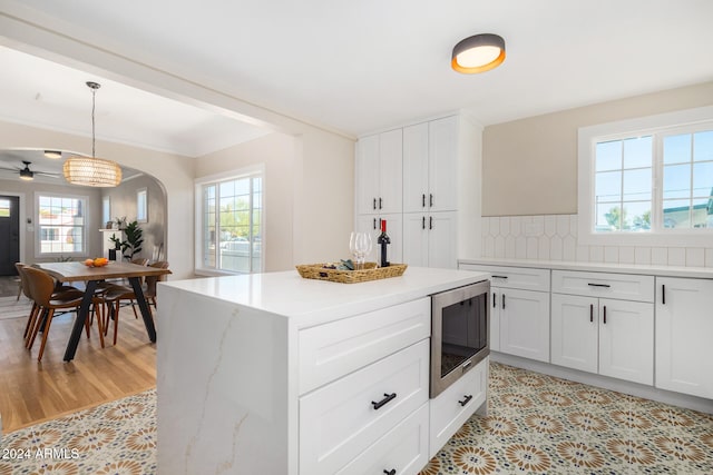 kitchen featuring pendant lighting, white cabinetry, stainless steel microwave, and ceiling fan