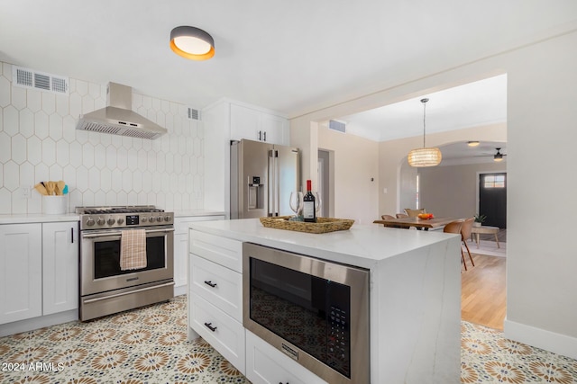 1921 E Yale St, Phoenix, AZ 85006 - kitchen featuring stainless steel appliances, wall chimney range hood, tasteful backsplash, light countertops, and white cabinets