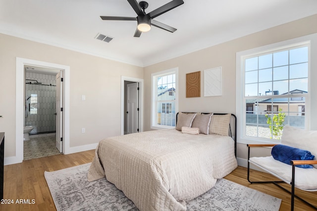 bedroom featuring ensuite bathroom, crown molding, ceiling fan, and light wood-type flooring