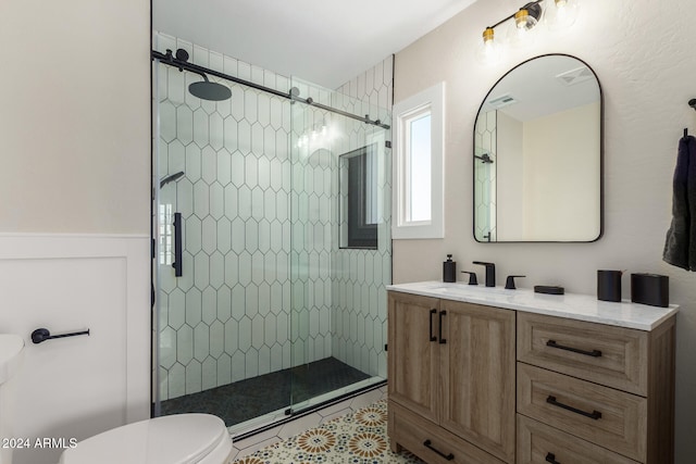 bathroom with a tile shower, tile patterned flooring, vanity, and toilet