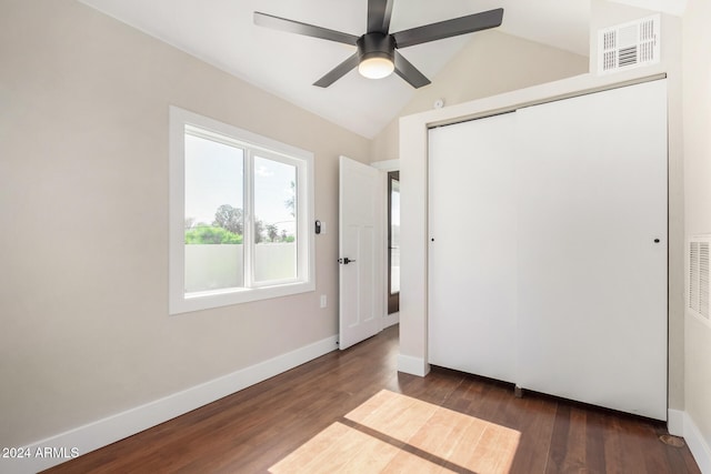 unfurnished bedroom with ceiling fan, a closet, dark hardwood / wood-style flooring, and vaulted ceiling