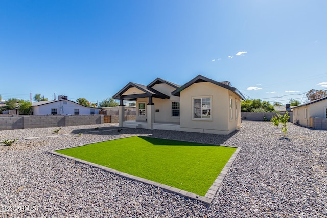 rear view of property featuring a lawn