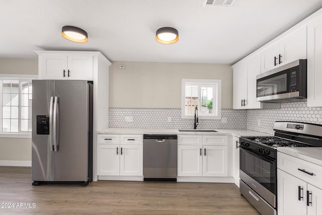 1921 E Yale St, Phoenix, AZ 85006 - kitchen featuring appliances with stainless steel finishes, light countertops, decorative backsplash, and white cabinetry