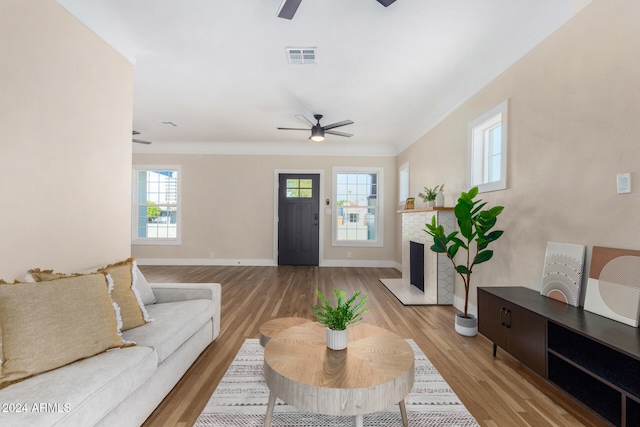 living room featuring ceiling fan, light hardwood / wood-style flooring, and crown molding