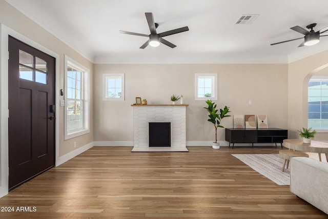 1921 E Yale St, Phoenix, AZ 85006 - living room with ceiling fan, wood finished floors, arched walkways, a fireplace, and crown molding