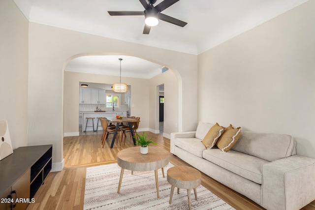 living room featuring ceiling fan, hardwood / wood-style floors, and ornamental molding